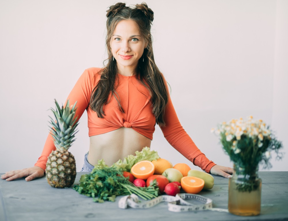 mujer ante mesa con poña y frutas